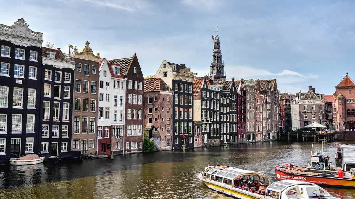 Traveller checking a phone by an Amsterdam canal after setting up the best eSIM Netherlands plan